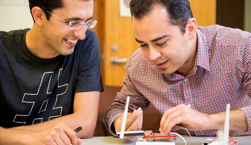 Two computer science students shown working on a project